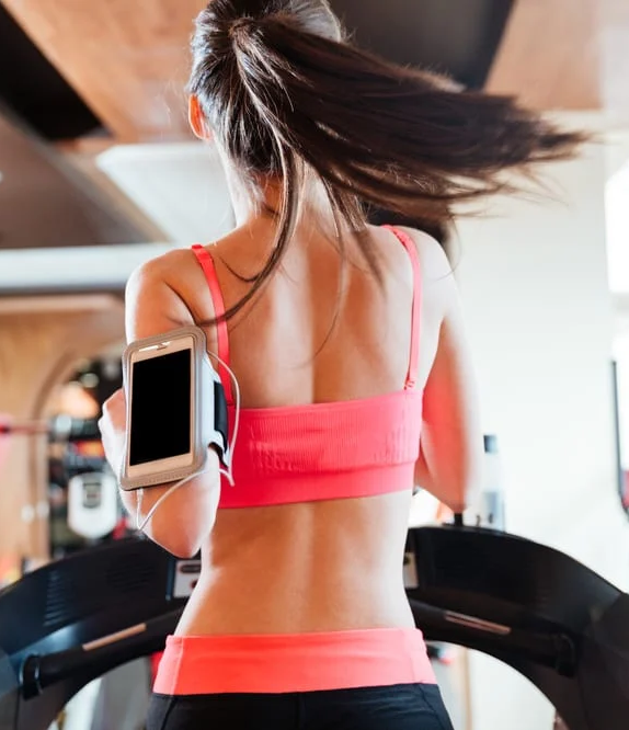 mulher usando o aplicativo Fit Tracker enquanto corre na esteira